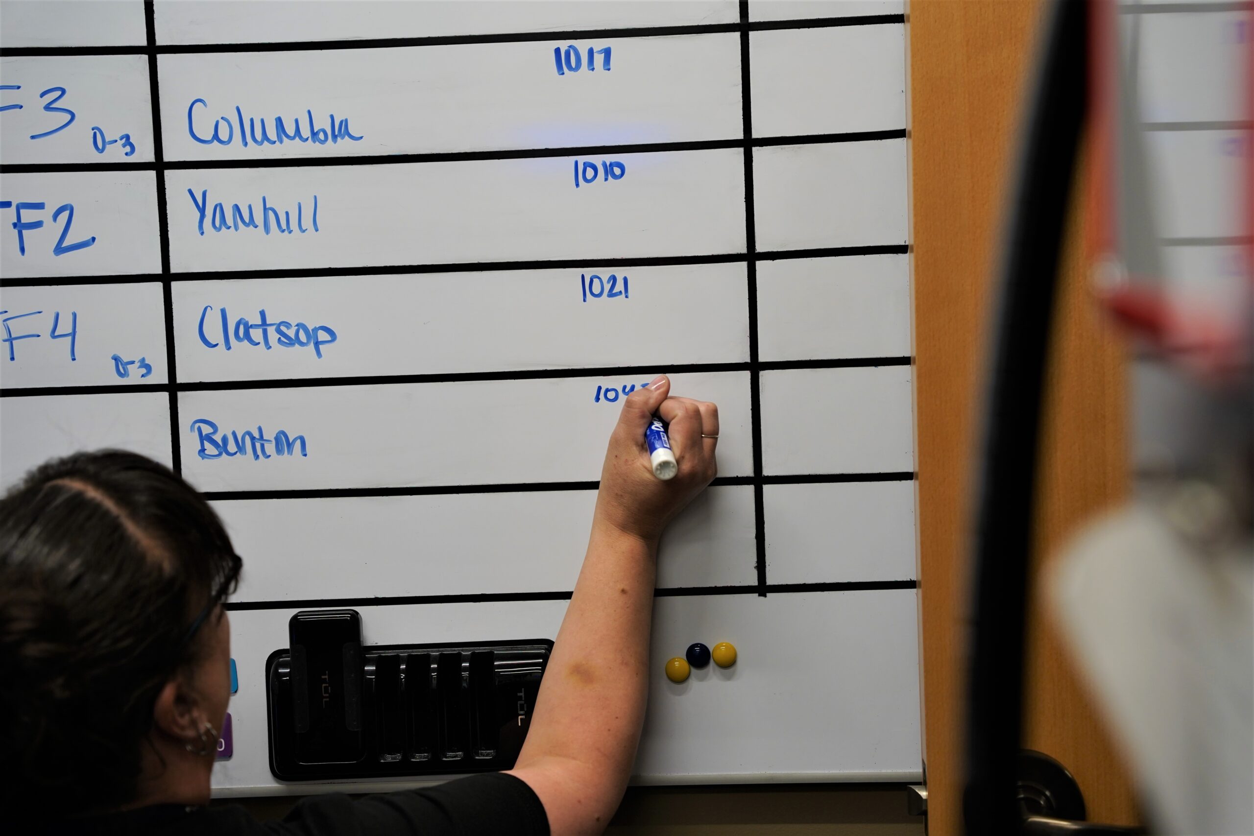 Employee writes on whiteboard at OSFM Agency Operations Center