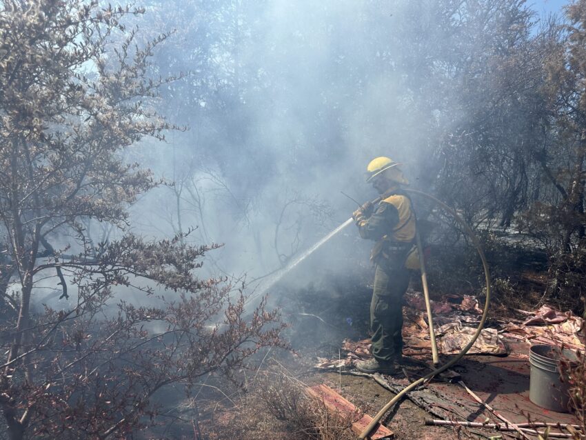 Firefighter spraying water on the golden fire in Klamath County