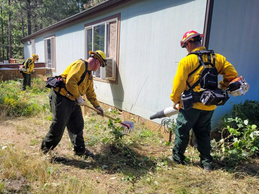 Oregon Firefighters creating defensible space around a home near the Smith River Complex