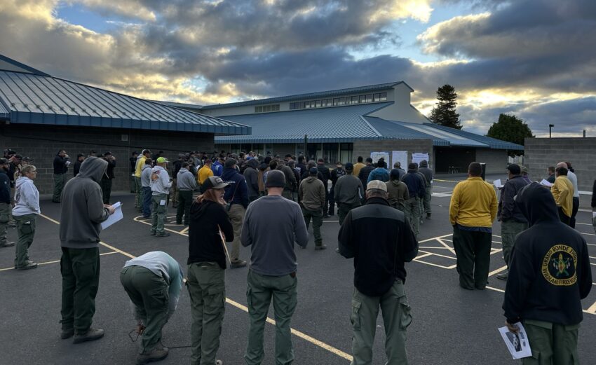 Firefighters being briefed. Standing near a building