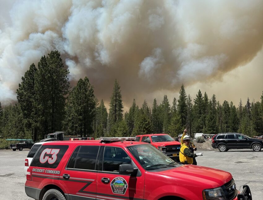 A fire command vehicle with smoke in the background