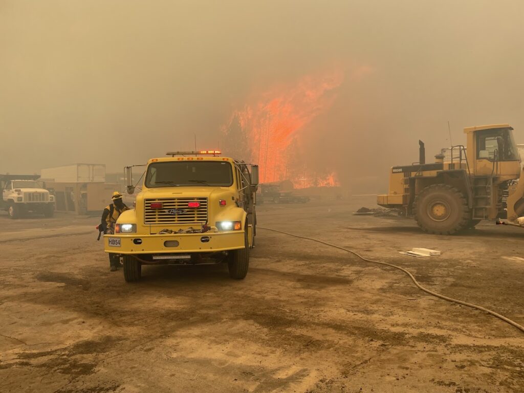 A fire engine with flames in the background