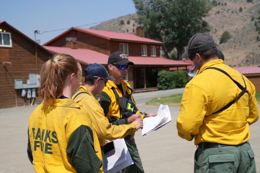 Firefighters discussing plans in a parking lot on the Falls Fire in Harney County