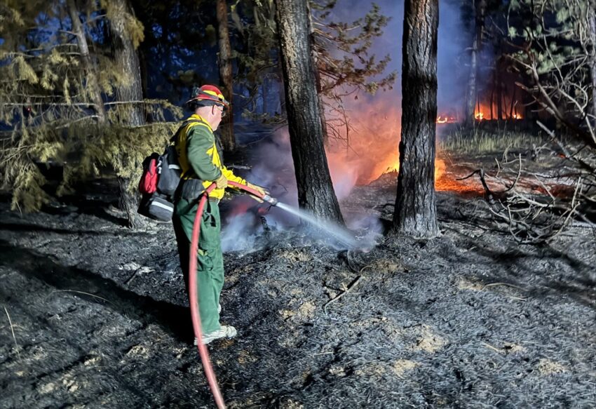 A firefighter spraying water on a fire in Eastern Oregon