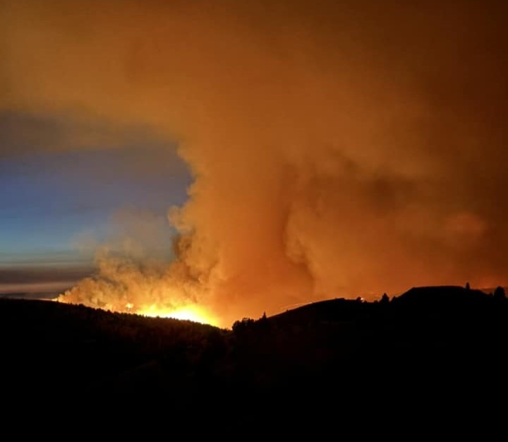 Photo of the landscape at night with fire and smoke from the Lone Rock Fire.