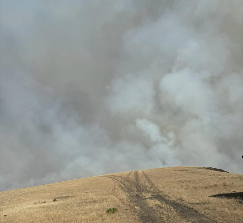 Photo of the landscape with smoke in the background from the Lone Rock Fire