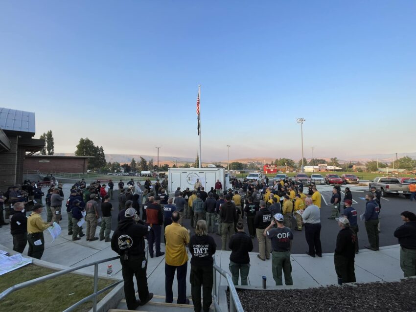 Firefighters standing around a map during a morning briefing.