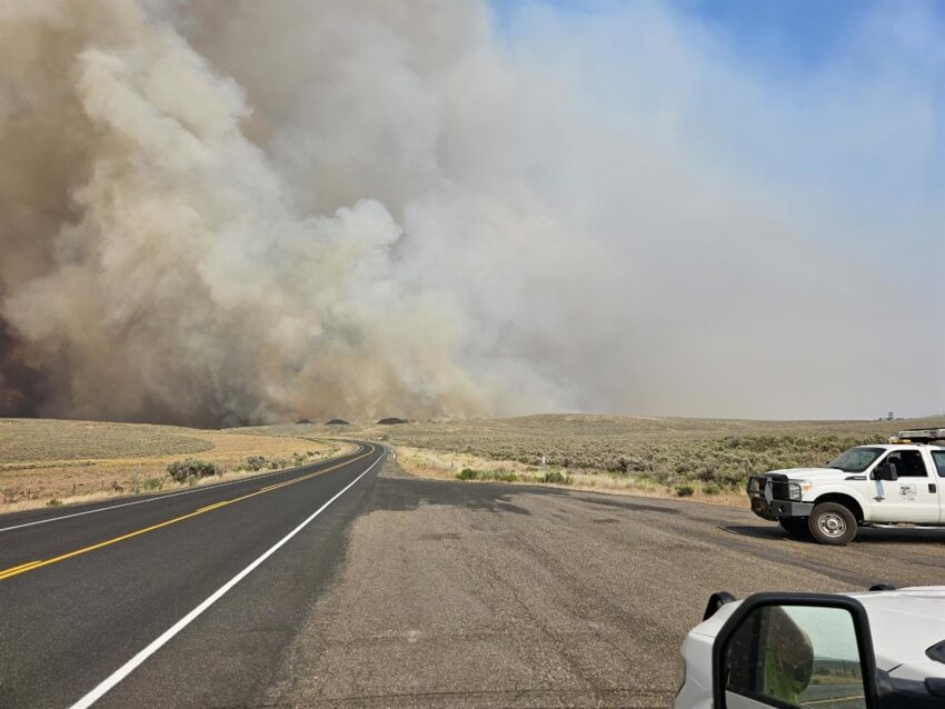 A wildfire blazing the background of a highway near Borgan