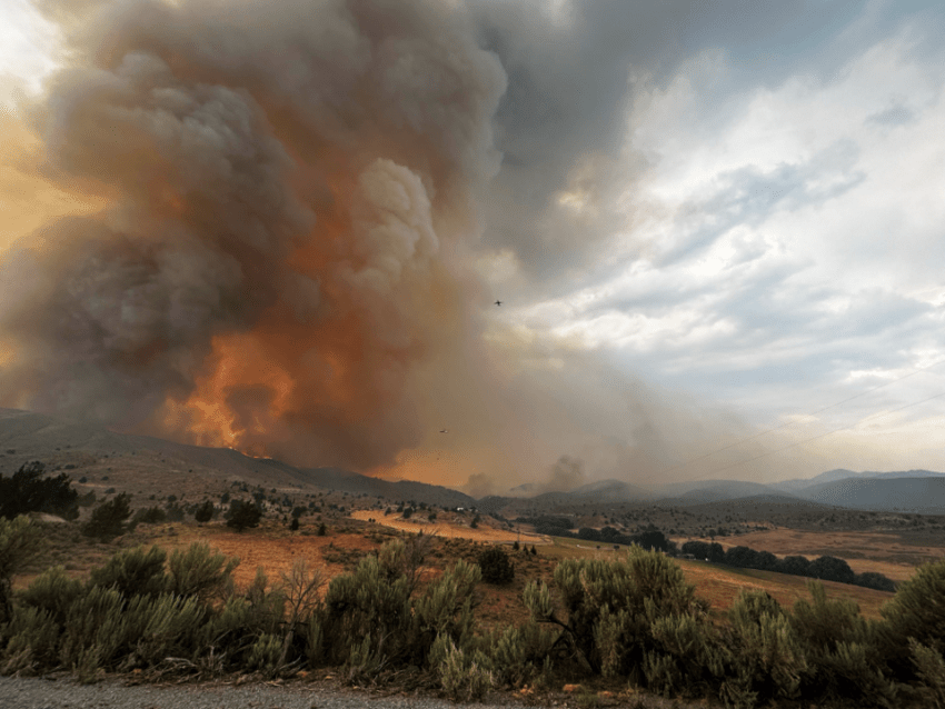 Smoke rising from the Durkee Fire in eastern oregon. A plane is also flying by