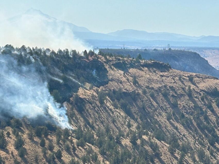 Elk Lane Fire - smoke rising from the canyon rim with a mountain in the background.