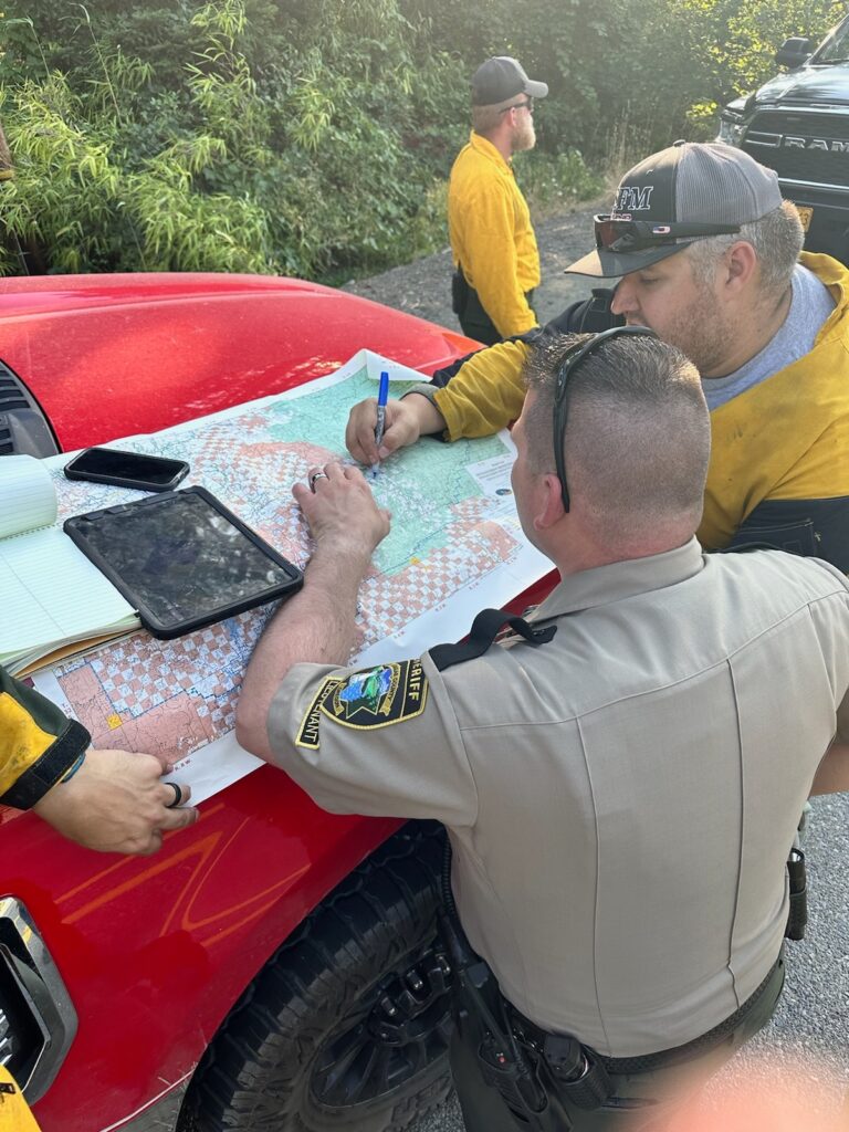 OSFM staff looking at a fire map on the hood of a fire vehicle at the Tiller Trail Fire in Douglas County, Oregon.