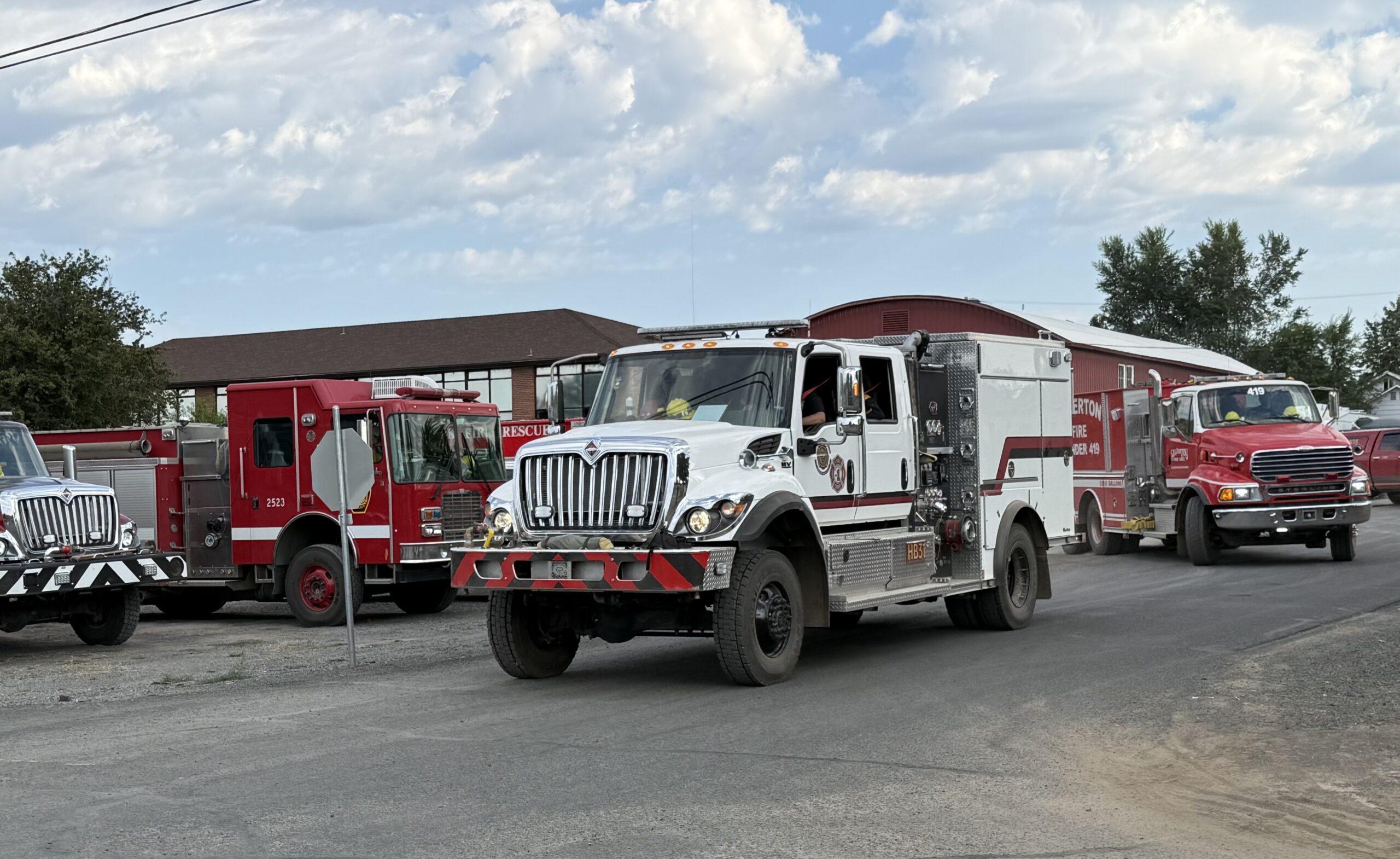 A line of fire apparatus driving to a fire.