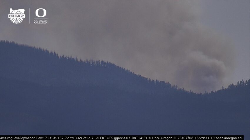 Photo of a tree-lined hill with heavy smoke in the air from the Rogue Valley.