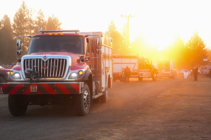 A fire engine with the sun rising in the background.